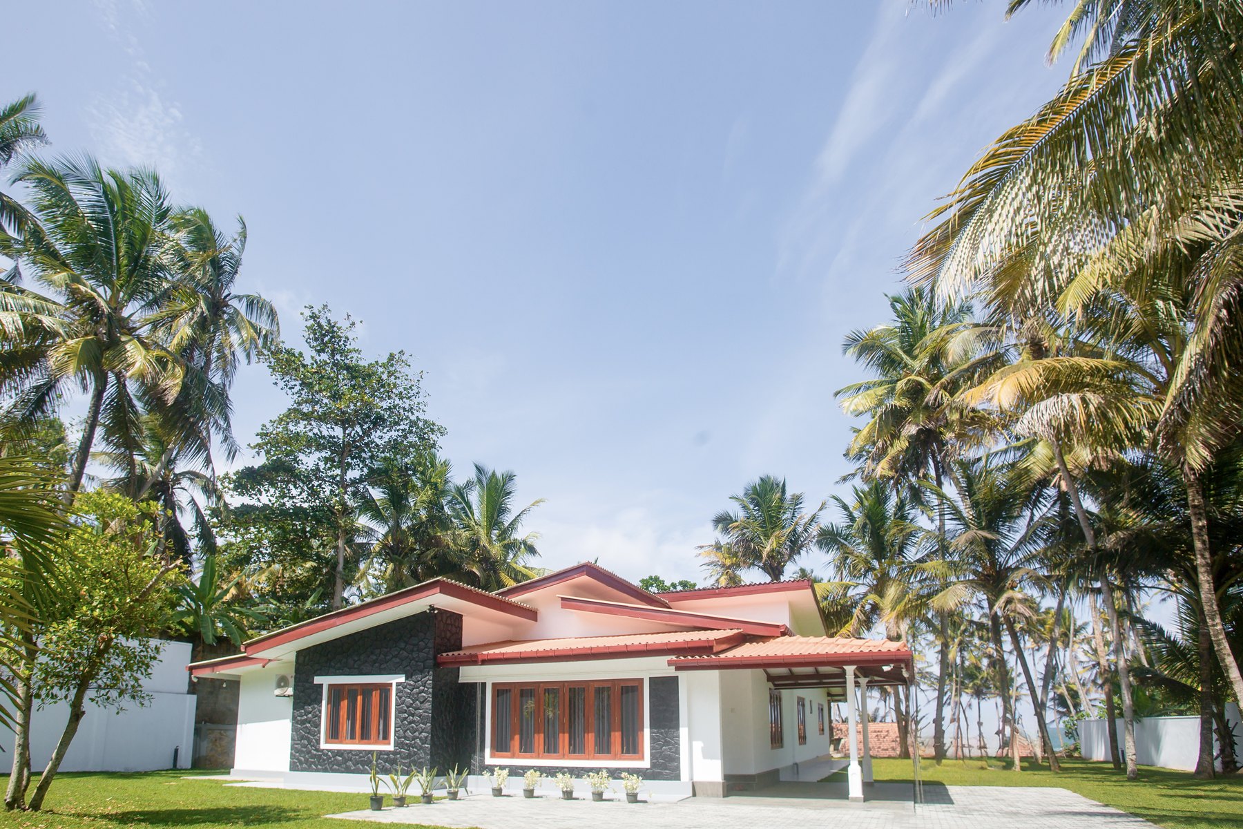 Oceania Villa under coconut palms on a sunny day