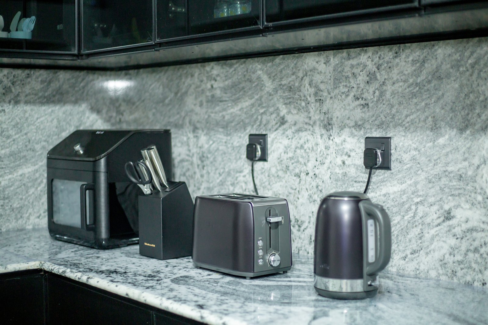 Matching black appliances on the marble kitchen counter